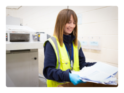 a woman looking at some paper in a factory